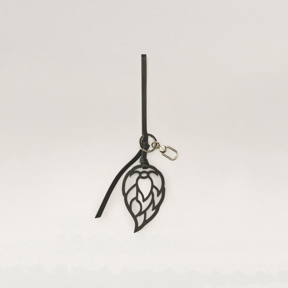 Shop the Signature Seed Logo Leather Charm in Black | Helen Kaminski
